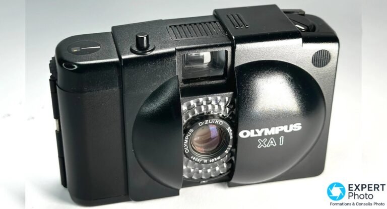 Olympus XA1 : avis et guide d’achat occasion du compact argentique sans pile Olympus XA1 noir, clapet ouvert, objectif D.Zuiko 35mm f/4, flash externe monté, angle 3/4 avant gauche