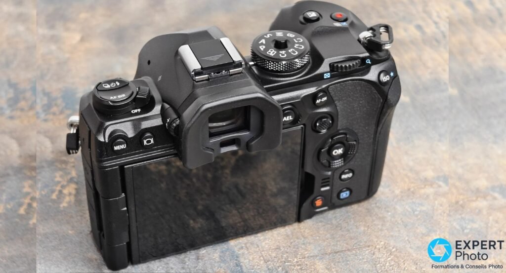 Face arrière OM System OM-1 Mark II boîtier nu, écran fermé, touches MENU, OK, AF-ON, INFO visibles 