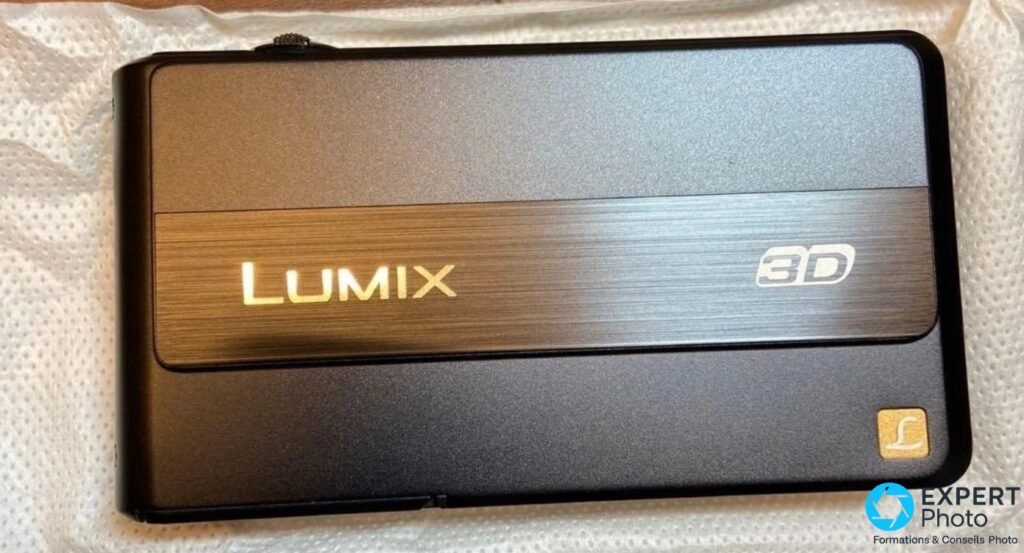 Panasonic DMC-3D1 noir face arrière sur fond blanc, écran éteint, logo Lumix doré, marquage 3D argenté