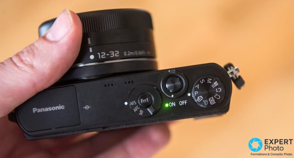 Dessus du Panasonic Lumix GM1, molette de modes P/S/A/M visible, commutateur ON avec voyant vert allumé, sélecteur AFS-AFC-MF