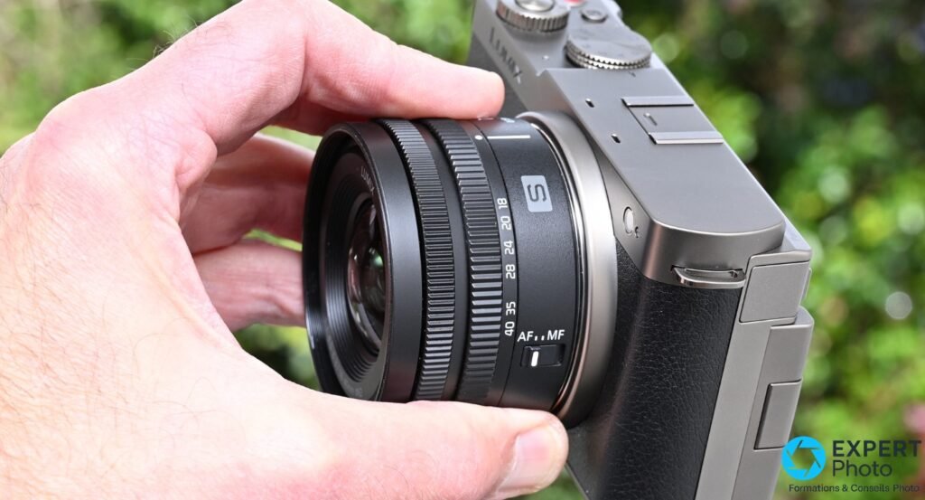 Panasonic Lumix S 18-40mm sur boîtier Lumix S, bague focales 18-40 et commutateur AF/MF visibles, tenu en main