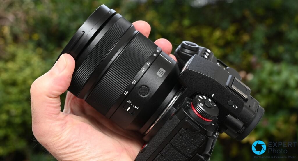 Objectif Panasonic Lumix S 24-60mm f/2.8 monté sur boîtier Lumix S, profil côté commutateur AF/MF, tenu en main