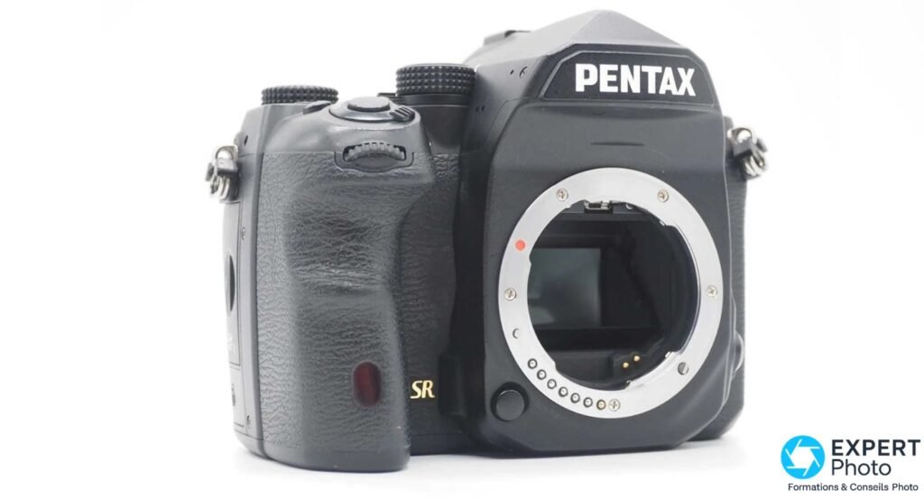 Pentax K-1 noir 3/4 avant droit, boîtier nu, poignée grip texturée et inscription SR dorée sur la façade
