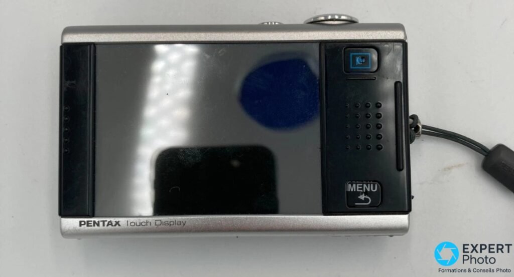 Dos du Pentax Optio T10 : grand écran tactile éteint avec reflets, inscription PENTAX Touch Display en bas, bouton Menu visible