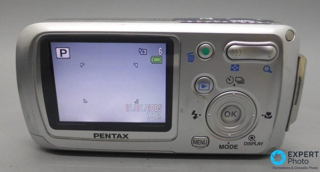Pentax Optio WP argent, dos avec écran LCD allumé mode P, date 01/01/2005, boutons MENU MODE DISPLAY et croix OK