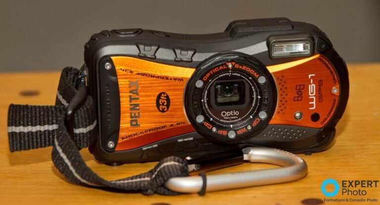 Pentax WG-1 en occasion : pourquoi l’état des joints compte plus que la fiche technique Pentax WG-1 GPS orange, face avant : objectif Optical 5x Zoom entouré de 5 LED macro, inscription Optio et WG-1 GPS visible