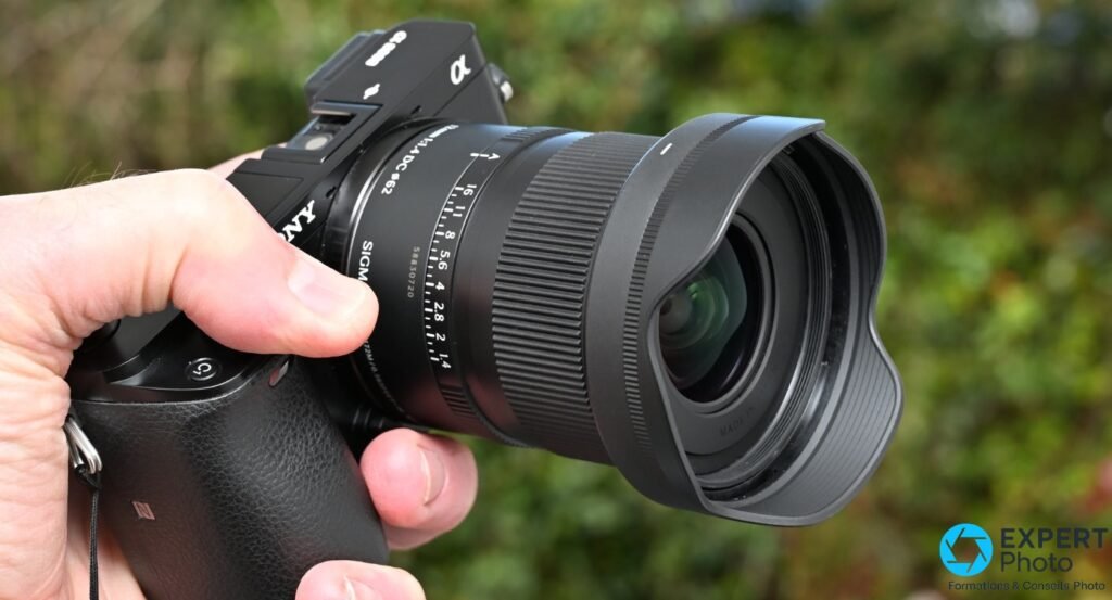 Sigma 12mm f/1.4 DC Contemporary avec pare-soleil pétale monté, profil droit, sur boîtier Sony α, gravage 12mm 1:4 DC ⌀62 et SIGMA lisibles