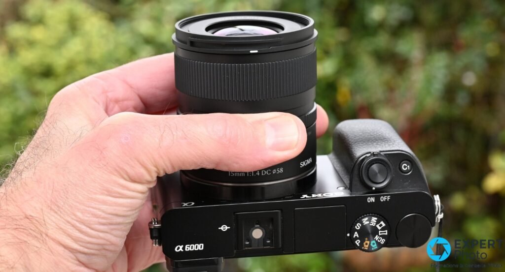  Sigma 15mm f/1.4 DC Contemporary en plongée sur Sony α 6000 : inscription 15mm 1:1.4 DC ø58 et SIGMA lisibles, molette de modes visible