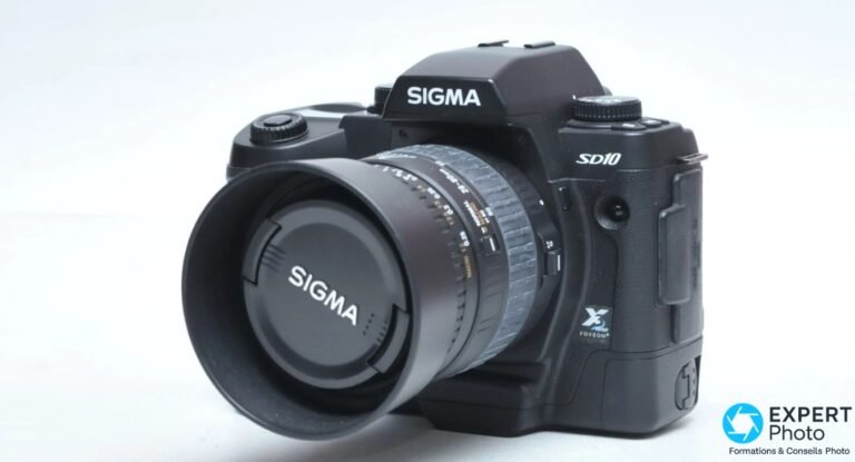 Sigma SD10 noir vu de 3/4 avant, objectif zoom Sigma monté avec bouchon, badge X3 Foveon et marquage SD10 visibles