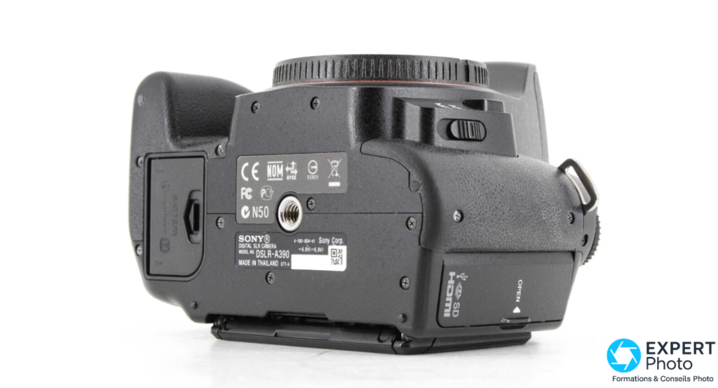 Sony Alpha A390 vu de dessous : plaque signalétique DSLR-A390 Made in Thailand, filetage trépied central, étiquette CE FCC N50