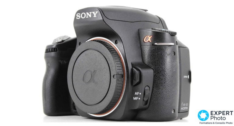 Sony Alpha A390 boîtier noir vu de 3/4 avant, cache monture α, liseré cuivré, touches AF MF et logos SD HDMI visibles