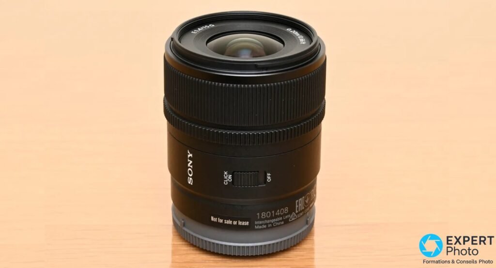 Objectif Sony E 15mm f/1.4 G noir, vue de face, lentille frontale exposée, commutateur Click ON/OFF sur le fût