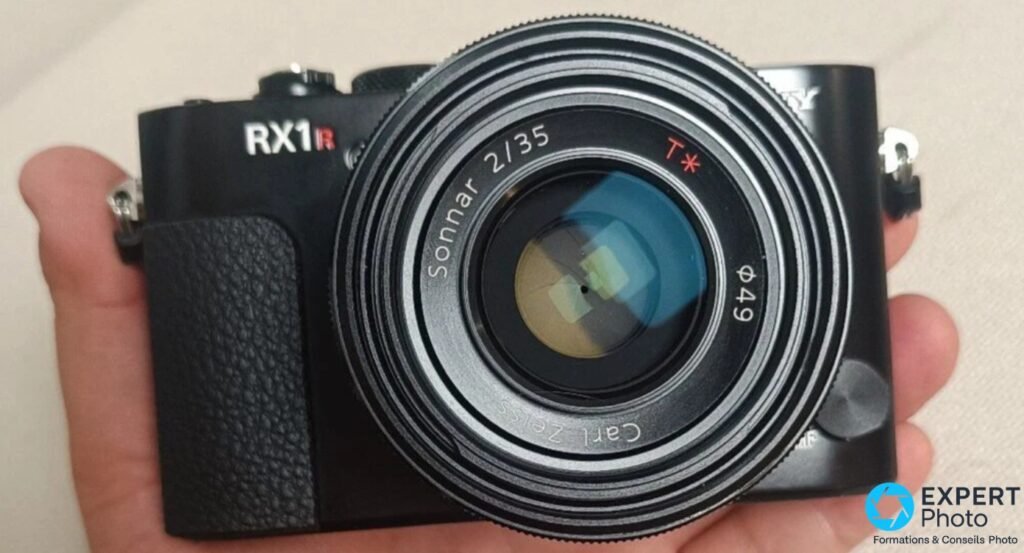 Gros plan objectif du Sony RX1R : inscriptions Carl Zeiss Sonnar 2/35 T★ ∅49 lisibles sur la bague, boîtier noir tenu en main