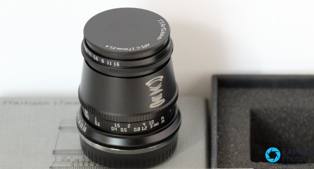 TTArtisan 17mm f/1.4 à la verticale, bouchon avant noir marqué TTArtisan, bague diaphragme APS-C 17mm F1.4 et graduations de MAP visibles