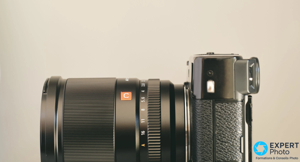 Viltrox AF 13mm f/1.4 XF profil latéral sur boîtier Fujifilm, bague diaphragme f/2 à A, bouton orange C, viseur optique du boîtier visible à droite