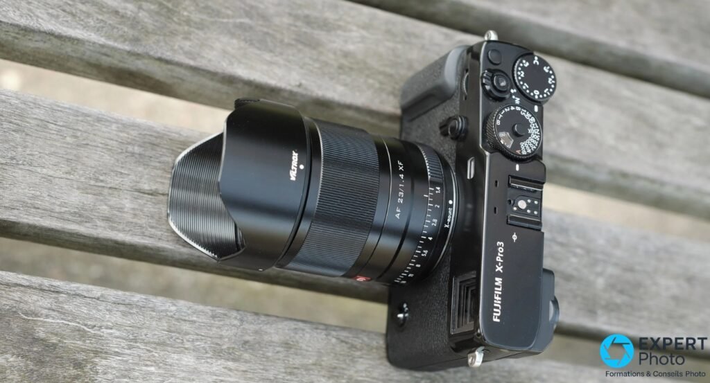 Viltrox AF 23mm f/1.4 XF avec inscription X-mount, monté sur Fujifilm X-Pro3, vue plongée sur lattes de bois, pare-soleil tulipe